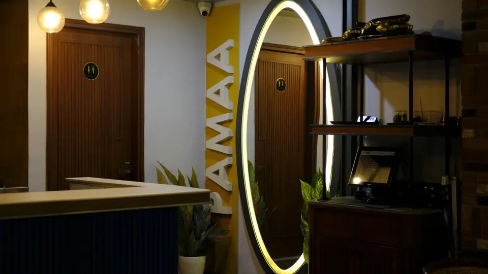 The Cafe Pamaa entrance with a glowing arched mirror and Pamaa sign