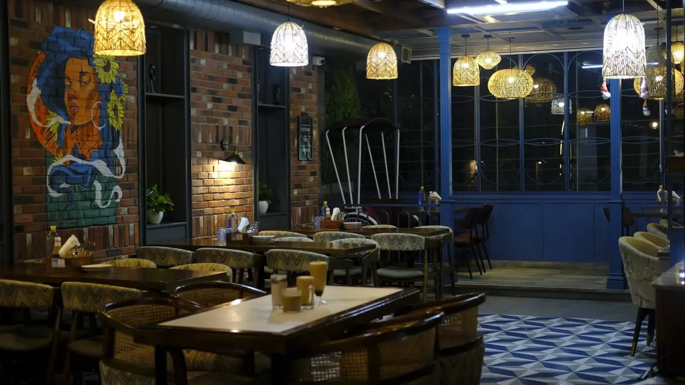 Cafe Pamaa interior in the evening, lit by hanging wicker lamps