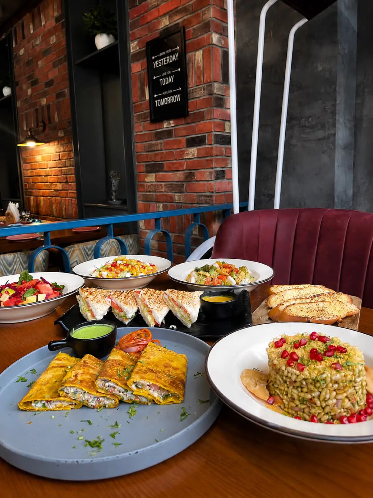 A spread of wraps, sandwiches, salads and garlic bread on the table